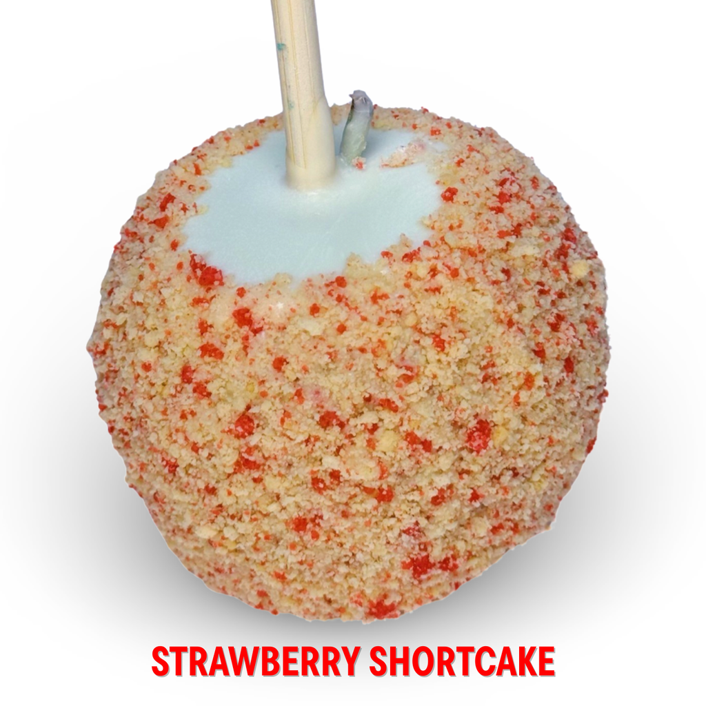 White chocolate caramel apple with strawberry shortcake crumble topping on a white background.
